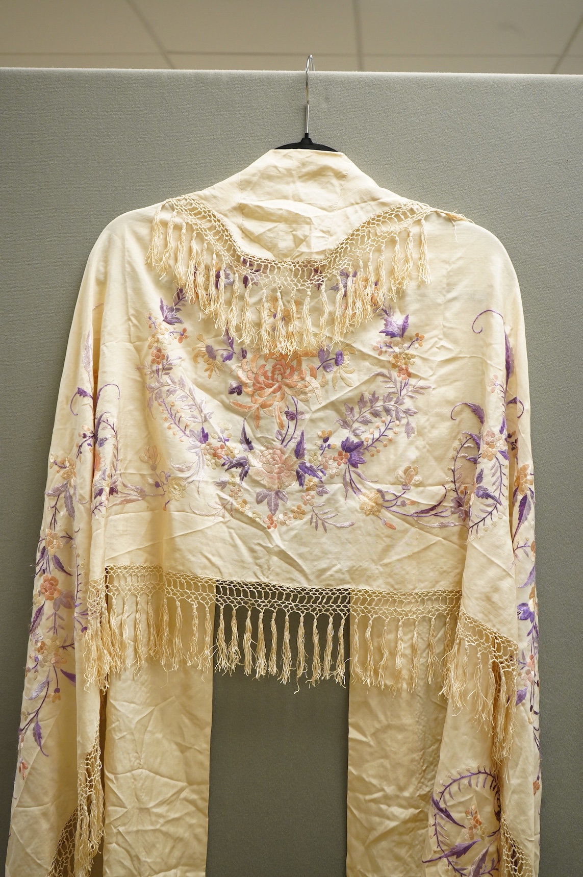 A 19th century Chinese cream silk embroidered and fringed stole, converted to a cape. Embroidered in pastel pinks and lilacs.192cm long